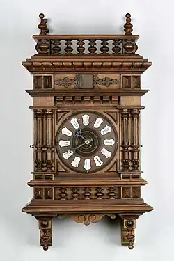 A neo-Renaissance example, dial with cartouches of Roman numerals, c. 1890 (Deutsches Uhrenmuseum, Inv. 09–3936)