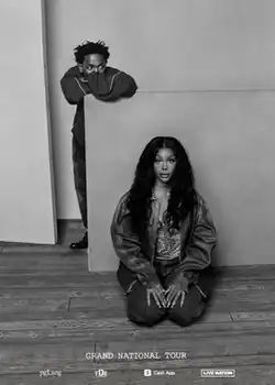 A black-and-white poster of Kendrick Lamar and SZA; SZA is kneeling on the floor and Lamar is leaning on a wall behind her